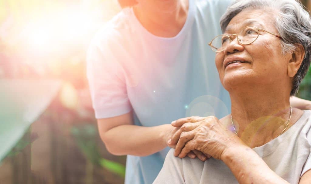 Caregiver, carer hand holding elder hand in hospice care.\